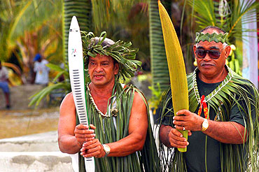 Vaianu and Papa Pia. Vaianu holds the Queens Baton while Papa Pia holds the stem of the coconut tree -known by locals as the tree of life because it provides shelter, food and decoration.