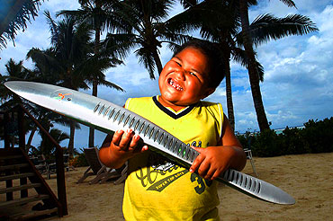 Cheeky grin. Kayraaua, 5 is thrilled to hold the baton as it travels around the island of Rarotonga during its visit to the Cook Islands.